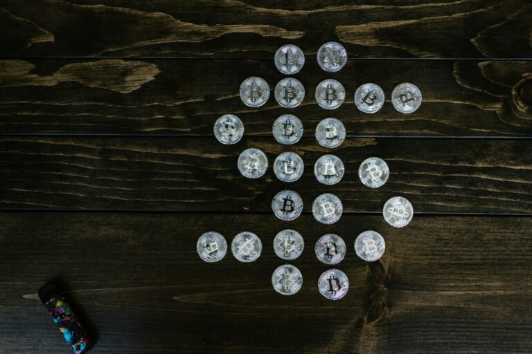 Flat lay of Bitcoin coins arranged in a shape on a wooden surface representing digital currency.