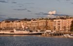 Elegant view of Geneva's waterfront with historic architecture at sunset.