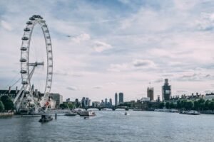Scenic view of the London Eye on the River Thames with clear blue skies and city skyline.