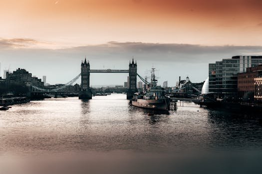 Tower Bridge in London at sunset with reflections on the River Thames, depicting urban beauty.