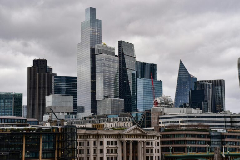 A dramatic view of London's city skyline featuring iconic modern skyscrapers.