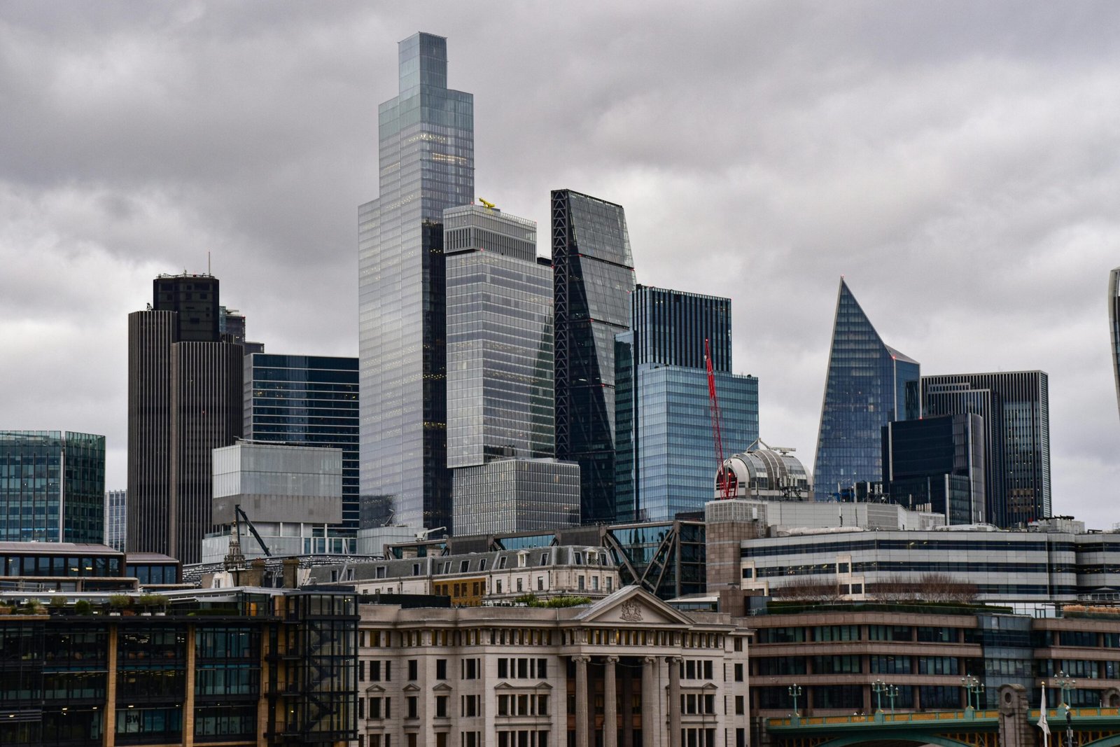 A dramatic view of London's city skyline featuring iconic modern skyscrapers.