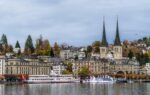 Charming autumn view of Lucerne, Switzerland, with iconic Chapel Bridge and waterway.