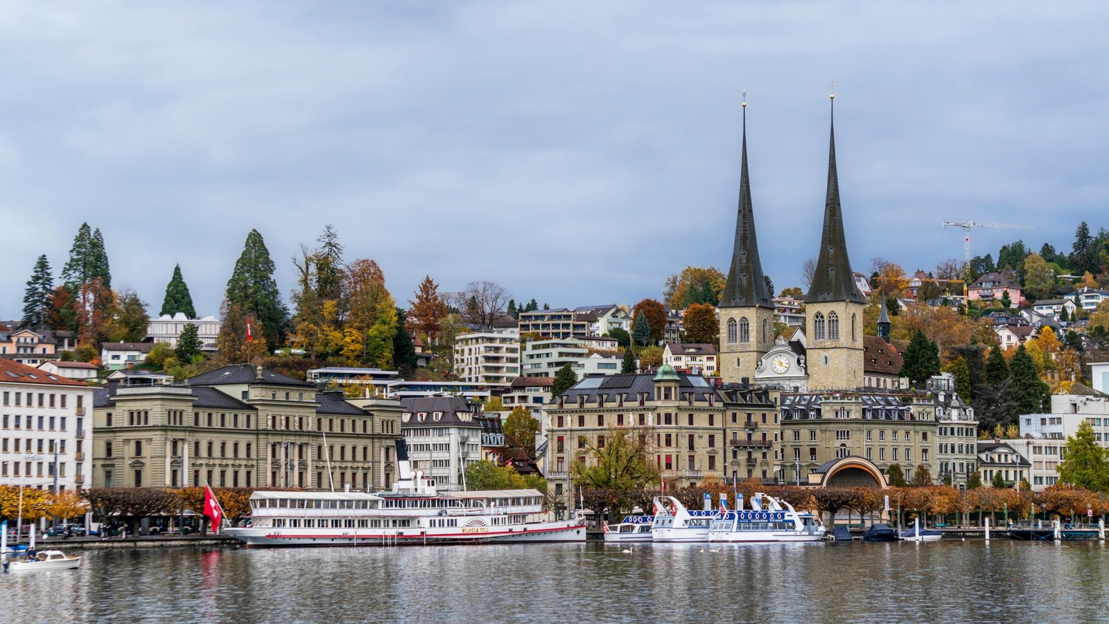 Charming autumn view of Lucerne, Switzerland, with iconic Chapel Bridge and waterway.
