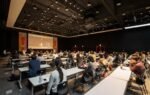 A diverse group attending a conference in a modern hall in Gwangju, South Korea.