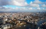Stunning aerial view of London featuring Tower Bridge and River Thames on a sunny day.