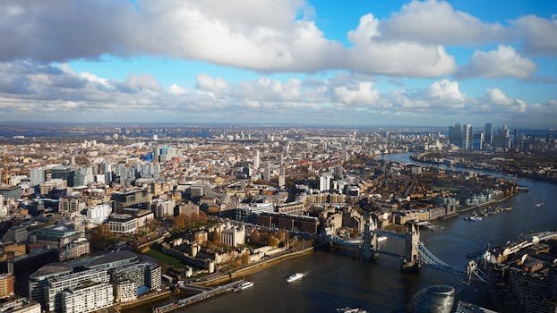 Stunning aerial view of London featuring Tower Bridge and River Thames on a sunny day.