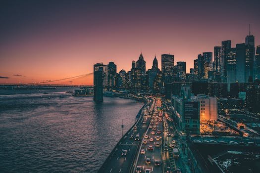 Beautiful view of New York skyline and Brooklyn Bridge at dusk, showcasing urban nightlife.