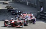 Thrilling Formula E cars racing through Monaco's iconic circuit, showcasing speed and competition.