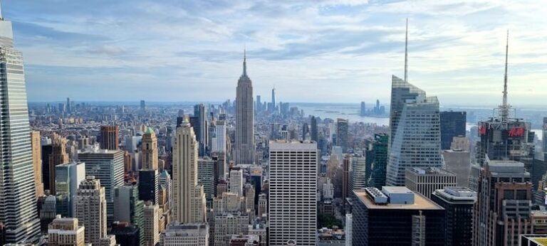 Aerial view of New York City skyline featuring iconic skyscrapers under a cloudy sky.
