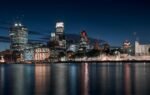 Captivating night view of modern London skyline with reflections on the Thames.