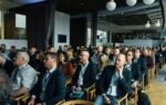 Business professionals attentively listening at an indoor conference meeting.