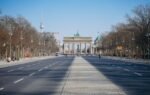 Wide view of Berlin's Brandenburg Gate and TV Tower on a clear day.