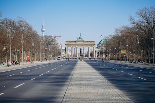 Wide view of Berlin's Brandenburg Gate and TV Tower on a clear day.
